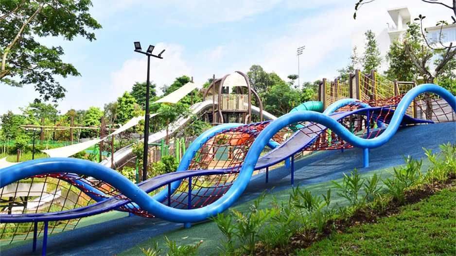 Children playing in a vibrant adventure playground in Singapore, showcasing climbing and sliding activities
